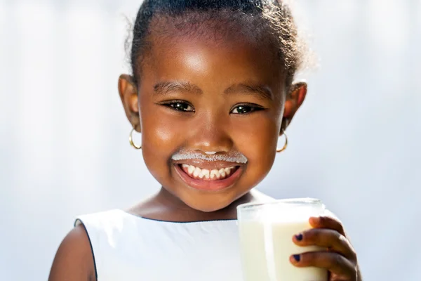 Schattig Afrikaanse meisje weergegeven: witte melk snor. — Stockfoto