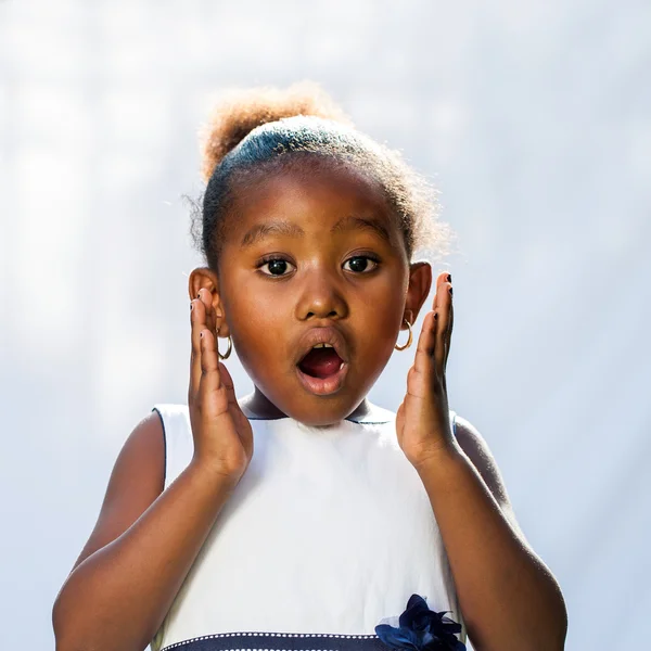 Porträt eines süßen afrikanischen Mädchens mit schockierendem Gesichtsausdruck. — Stockfoto