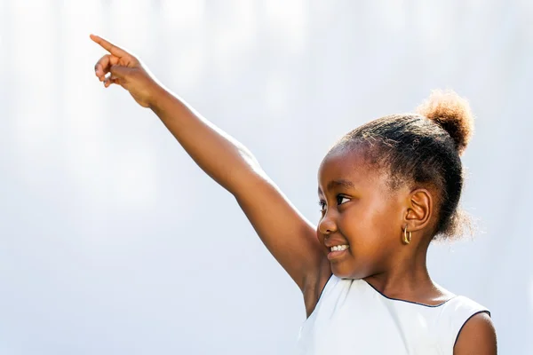 African girl pointing and looking at corner. — Stock Photo, Image