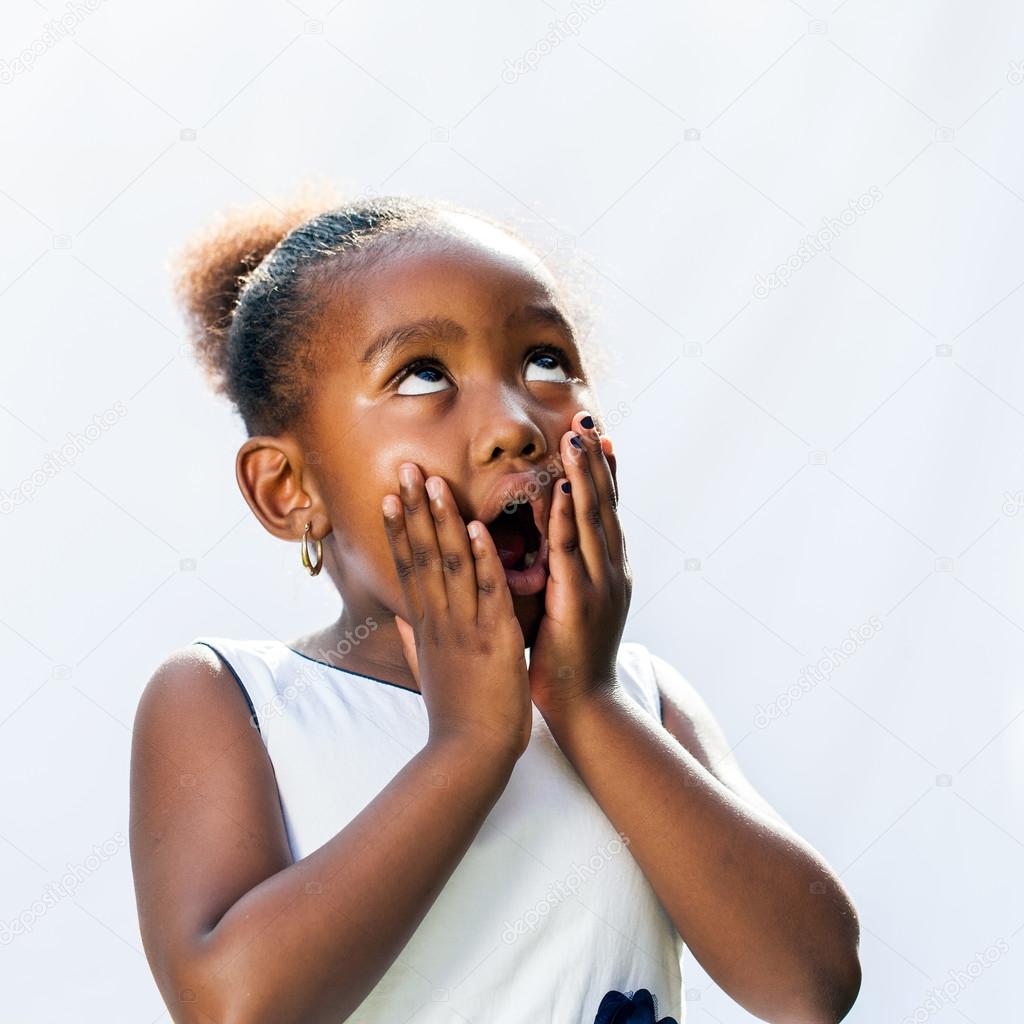 Surprised african girl with hands on face.