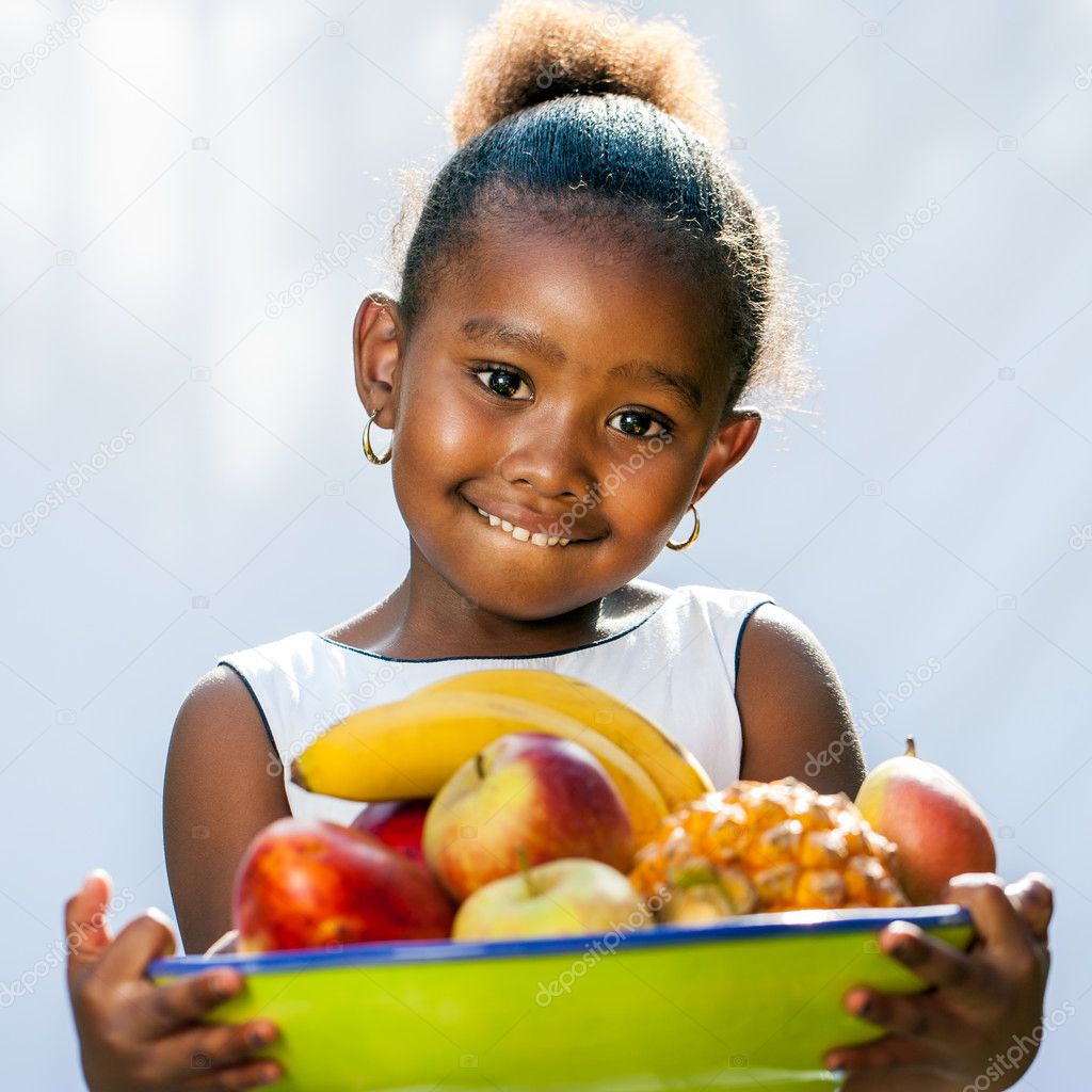 Cute african girl holding fruit bowl.