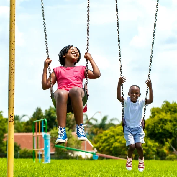 Crianças africanas se divertindo balançando no parque . — Fotografia de Stock