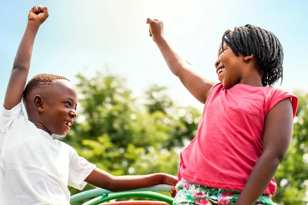 Niños africanos mirándose levantando las manos . — Foto de Stock