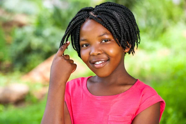 Cute African girl showing braided hair. — Stock Photo, Image