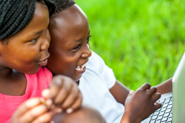 Los niños africanos se divierten en el ordenador portátil al aire libre . —  Fotos de Stock