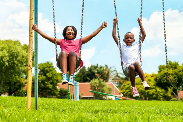 Afrikanische Kinder spielen auf Schaukel in Nachbarschaft. — Stockfoto