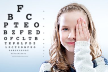 Child reviewing eyesight. clipart