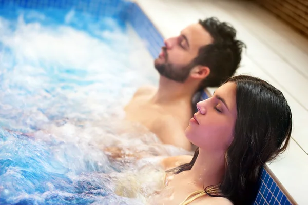 Couple relaxing in spa jacuzzi. — Stock Photo, Image