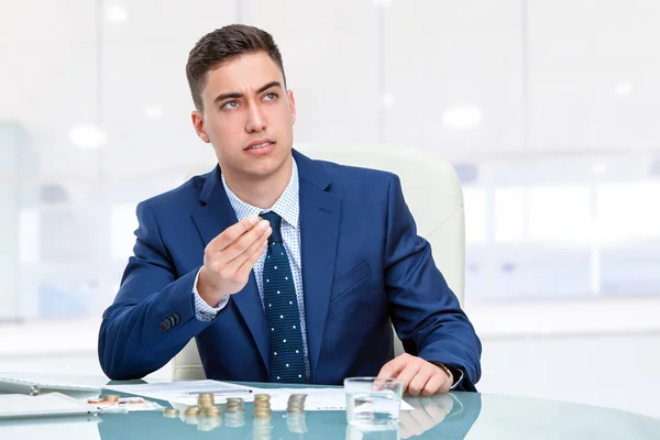 Empresário na mesa segurando dinheiro — Fotografia de Stock