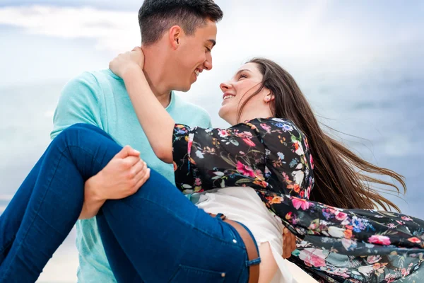 Pojke svängande flickvän i armar utomhus. — Stockfoto