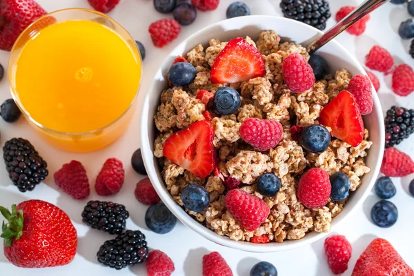 Müsli von oben mit roten Früchten und Orangensaft. — Stockfoto