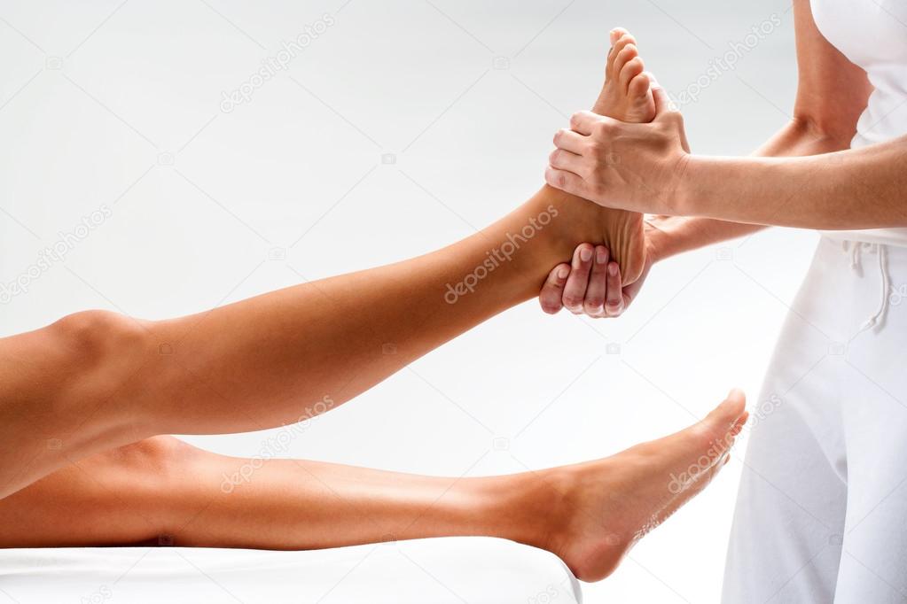Osteopath massaging female foot.