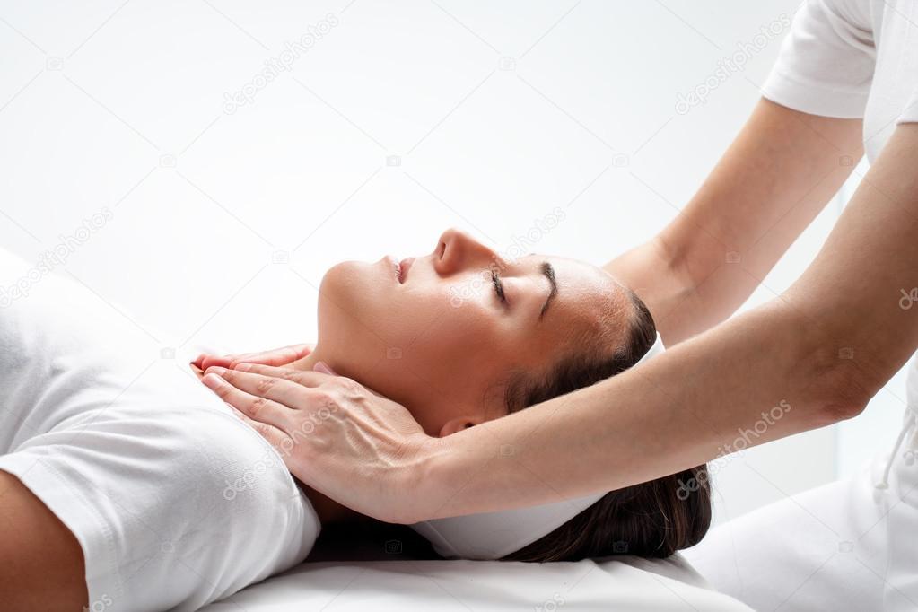 Therapist doing reiki on womans neck