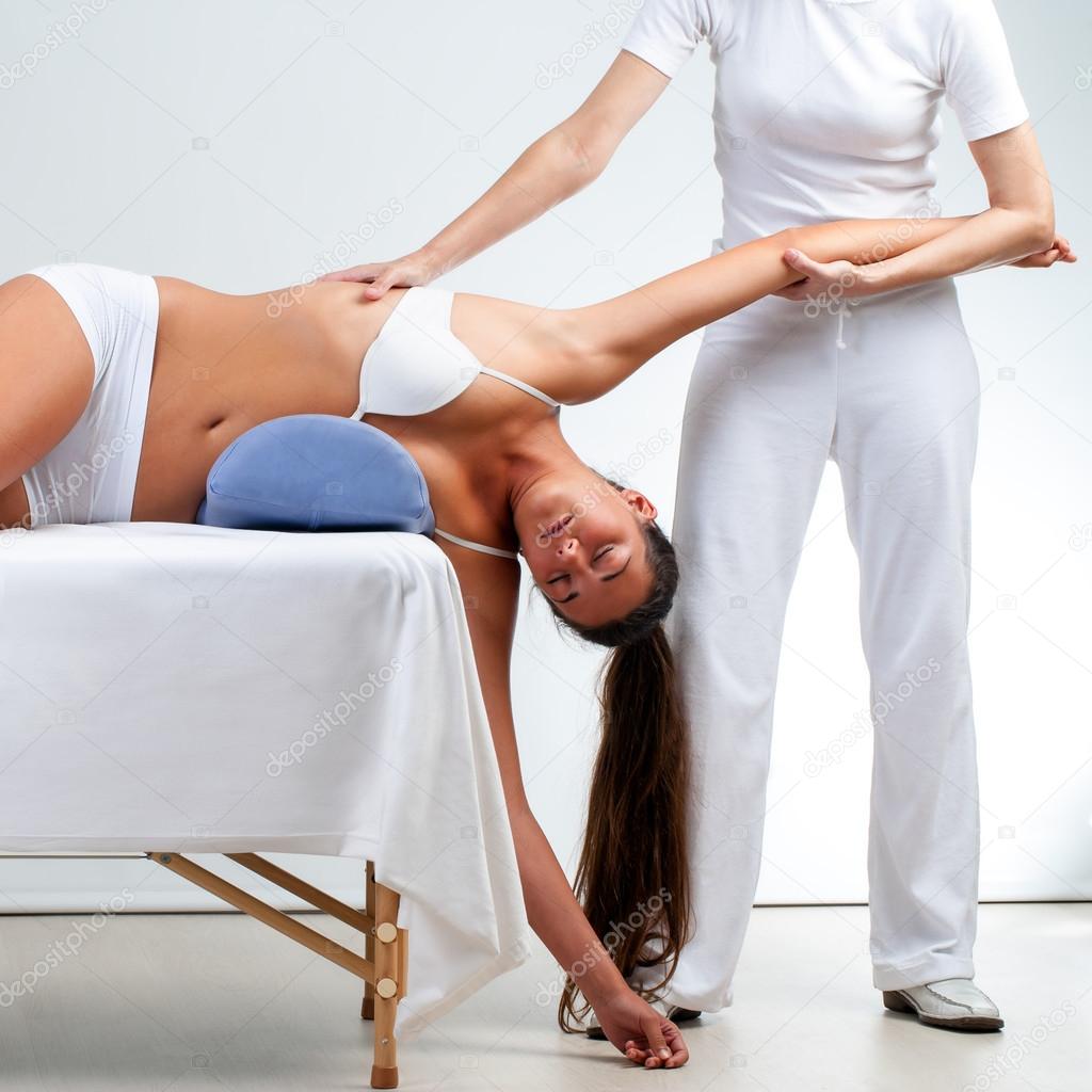 Therapist doing shoulder massage on woman.