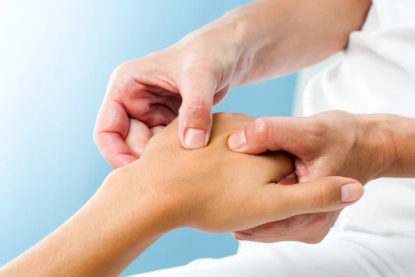 Terapeuta facendo massaggio sulla mano femminile — Foto Stock