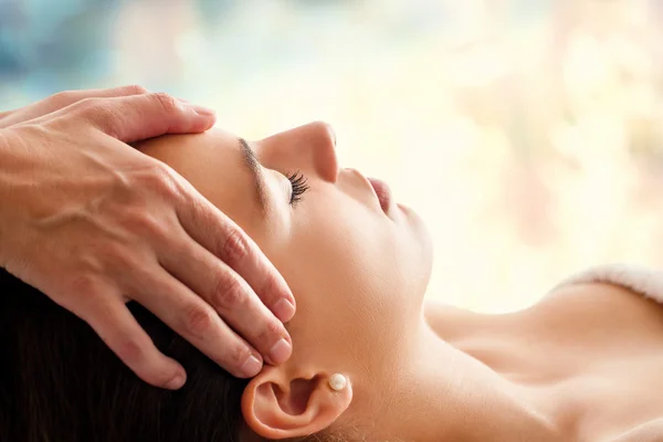 Jovem mulher fazendo massagem facial — Fotografia de Stock