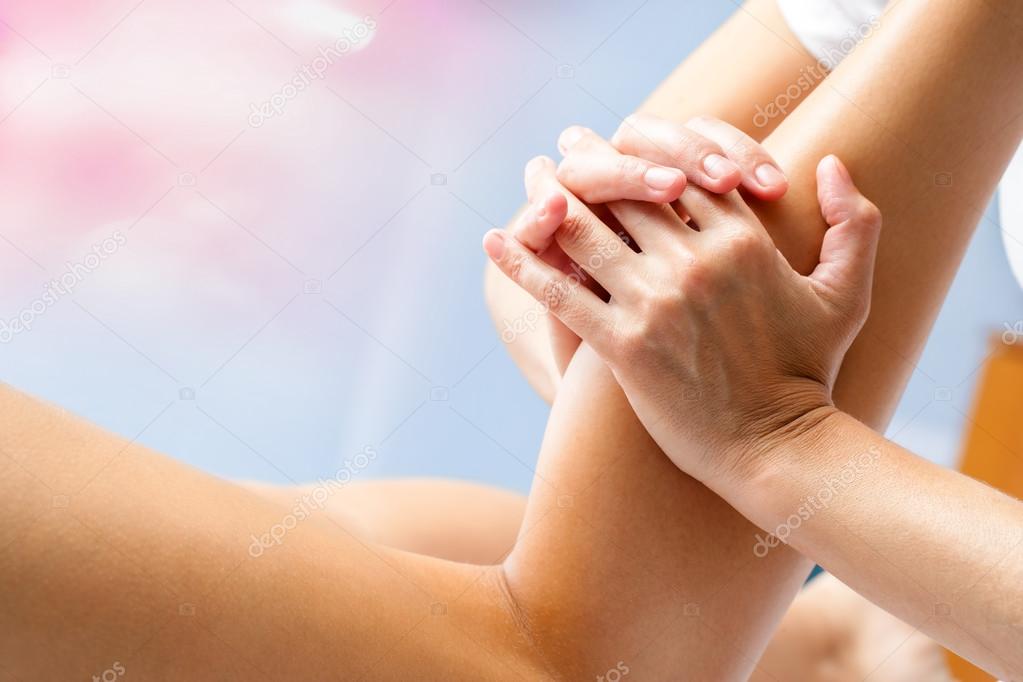osteopath massaging female calf muscle