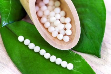 homeopathic pills on green leaves