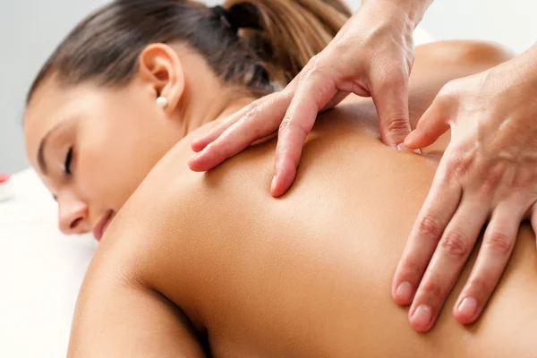 Terapista che applica pressione con i pollici sulla schiena . — Foto Stock