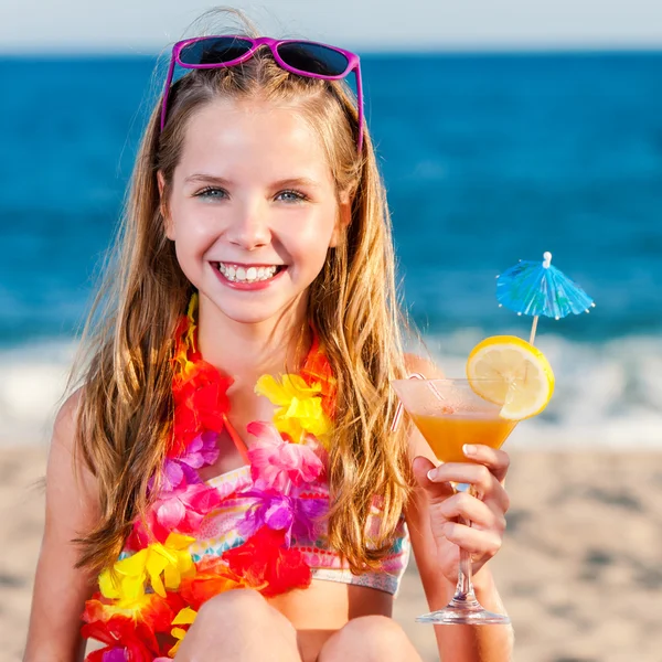 可爱的小女孩抱着水果鸡尾酒的海滩. — 图库照片