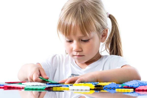 Kleines Mädchen spielt mit Puzzleteilen. — Stockfoto