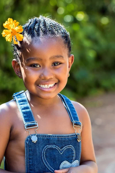 Menina africana bonito que coloca na grama verde — Fotografia de Stock