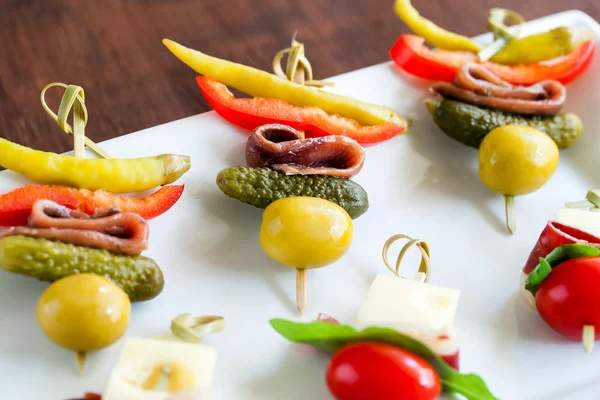 Mini anchovy appetizers mounted on skewers. — Stock Photo, Image