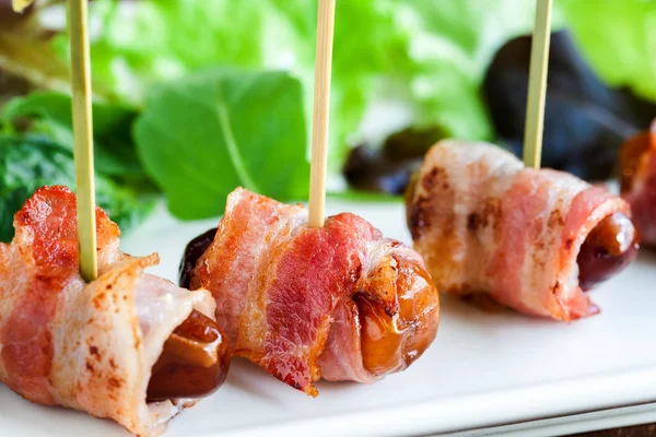 Appetizing dates with bacon skewers. — Stock Photo, Image