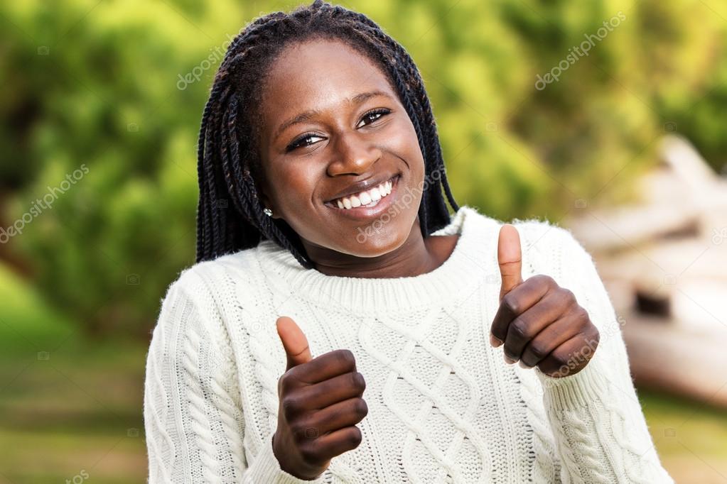 African teen gesturing thumbs up sign.