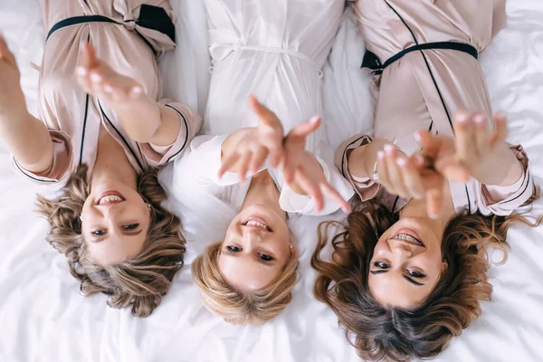 Chicas Acuestan Cama Sonriendo Levantando Las Manos Mostrando Manicura Boda — Foto de Stock