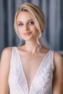 Gelinlik, duvak ve makyajlı güzel mutlu sarışın gelin. Gelinin düğün sabahı evde.