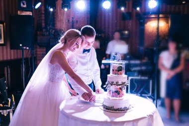 Restorandaki güzel çift düğün pastasını kesti.