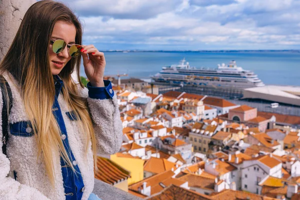 旅行者や観光客はかなり若い女の子がバルコニーに立って 晴れた日にヨーロッパの都市の中心部から上から眼鏡を通して見ています ポルトガルのリスボン — ストック写真