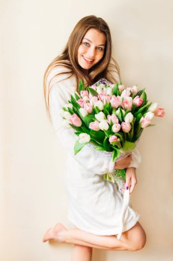 Üzerinde büyük bir buket beyaz ve pembe lale tutan gecelikli güzel bir kızın portresi. 