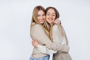 Sarı saçlı en iyi arkadaşlar keyifli bir şekilde eğleniyorlar. Güzel görünümlü kızlara sarılma portresi