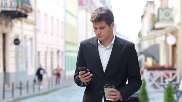 Genç Şık Bir Adam Sokakta Yürüyor Cep Telefonuyla Mesajlara Basıyor — Stok video