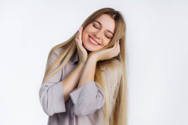 Rahatlamış bir kadının portresi. Nazikçe gülümsüyor. Mükemmel dişler gösteriyor..