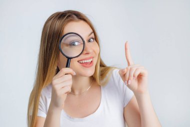 Güzel, genç, anlamlı ve gülümseyen, mavi gözlü, büyüteçten bakan, baş parmağını kaldıran, bir fikirle geldi..