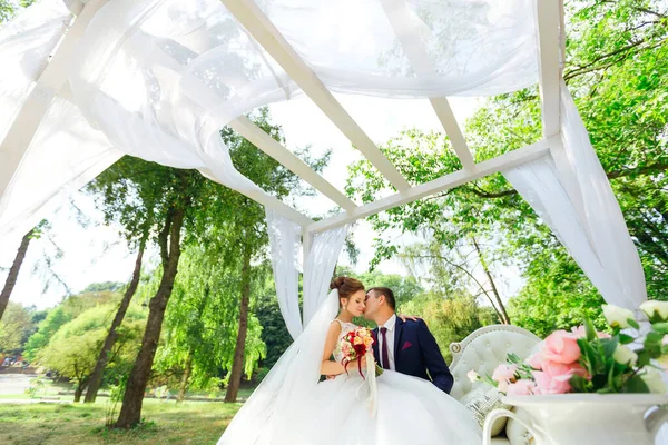 Les Mariés Assis Sur Banc Blanc Étreignant Sous Une Arche — Photo