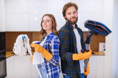 Temizlik eğlencelidir. Evde bahar temizliği yaparken süpürge ve süpürgeyle dans eden genç çift..