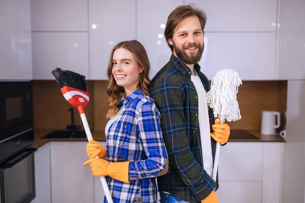 professional steam cleaners, washing and disinfection of floors. A man and a woman stand shoulder to shoulder and hold a mop in their hand. Services of cleaning companies.