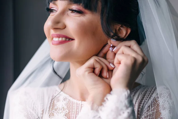 一个漂亮的女人很自然地把耳环戴在她的耳朵上 早上好 姑娘们 新娘在家里为婚礼作准备 — 图库照片
