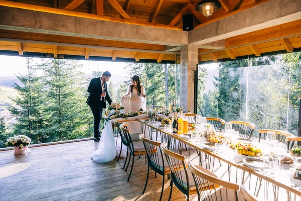 Молодята Сідають Красивий Весільний Стіл Панорамними Вікнами Видом Природу Після — стокове фото