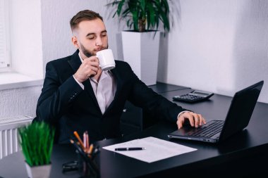 Avukat büro masasında çay içer. İş adamı iş yerinde kahve molası veriyor..