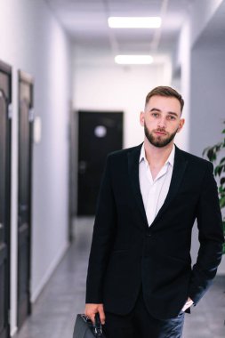 Ofis koridorunda genç bir işadamının portresi.