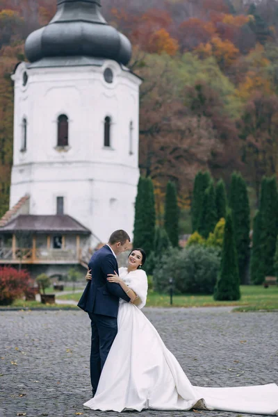 Ein Hochzeitspaar Umarmt Sich Vor Dem Hintergrund Einer Kirche Und — Stockfoto