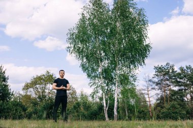 Sabahları ısınan ve esneyen atletik bir adamın tam boy portresi.