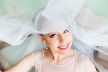 Yatak odasında saç stili ve düğün makyajı olan güzel bir gelin. Muhteşem bir kızın yakın çekimi.