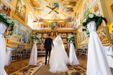 Lviv, Ukrayna - 5 Ekim 2017 - bir kadın ve bir erkek kilisede düğün merasimi düzenliyor. Düğün tacı takıyor - arkadan bir manzara - gelin ve damat..