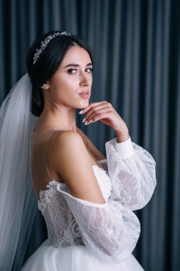 Beyaz elbiseli lüks gelin düğün törenine hazırlanırken poz veriyor..